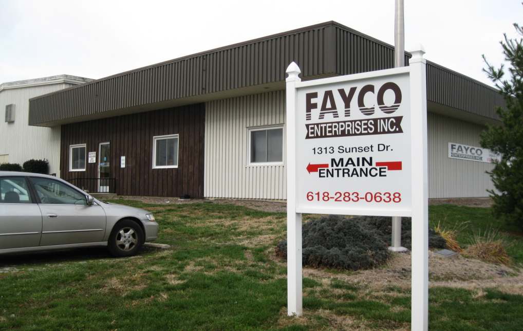 boxey office building exterior with flat roof, brown and ivory siding, grass, decorative bushes, entrance sign